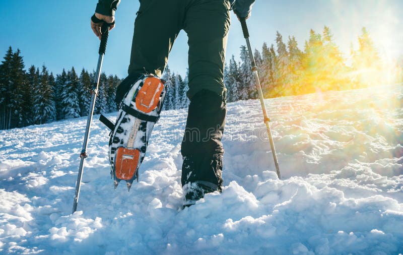 Fin De Tirer Sur Des Chaussures De Montagne Avec Des Crampons Et Des  Menottes De Neige Avec Des Rayons De Soleil De Rétroéclairage Photo stock -  Image du initialisation, expédition: 172522680