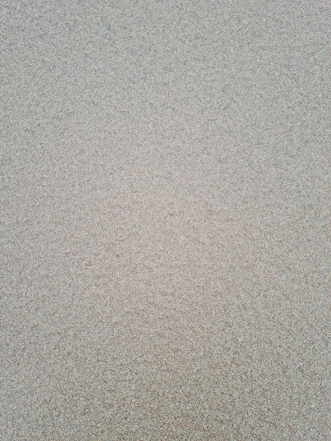 Fin textur av grov sand på stranden. Lager av färsk våt sand fryst av havsvattnets tidvattenvågor