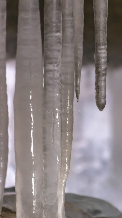Fin verticale vers le haut de la vue des glaçons doux et brillants sous un pont en hiver images stock Fin verticale vers le haut de la vue des glaçons doux et brillants sous un pont en hiver images stock