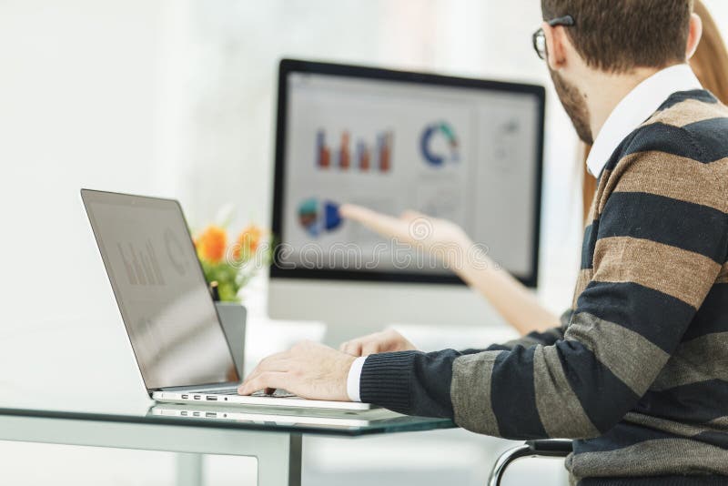 Finance specialist working on laptop with financial charts and marketing schemes royalty free stock photo Finance specialist working on laptop with financial charts and marketing schemes royalty free stock photo
