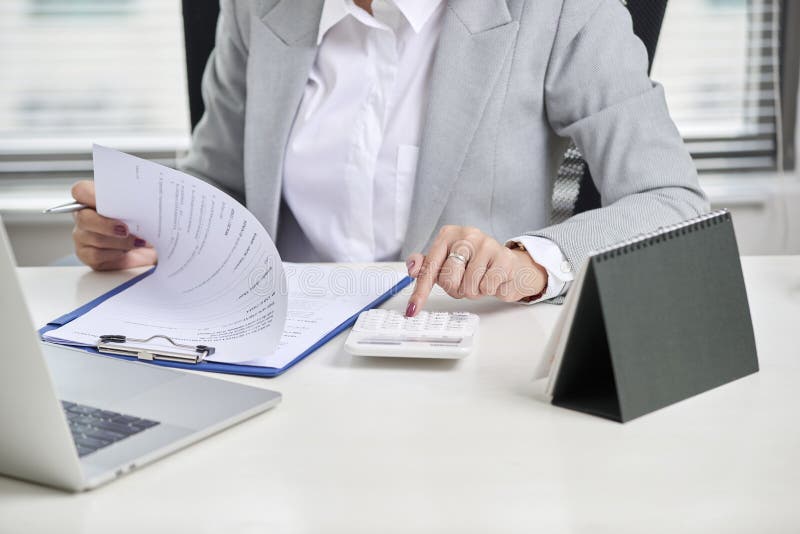 Financial Advisor Using Calculator Review Financial Statement on Desk