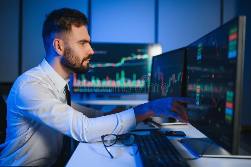 Financial Analyst Working on a Computer with Multi Monitor Workstation with Real Time Stocks royalty free stock image