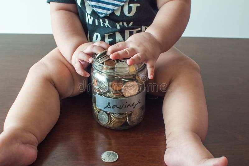 A baby boy is holding a jar filled with coins royalty free stock photos A baby boy is holding a jar filled with coins royalty free stock photos