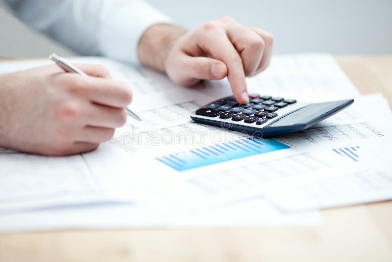 Financial data analyzing. Counting on calculator. stock images