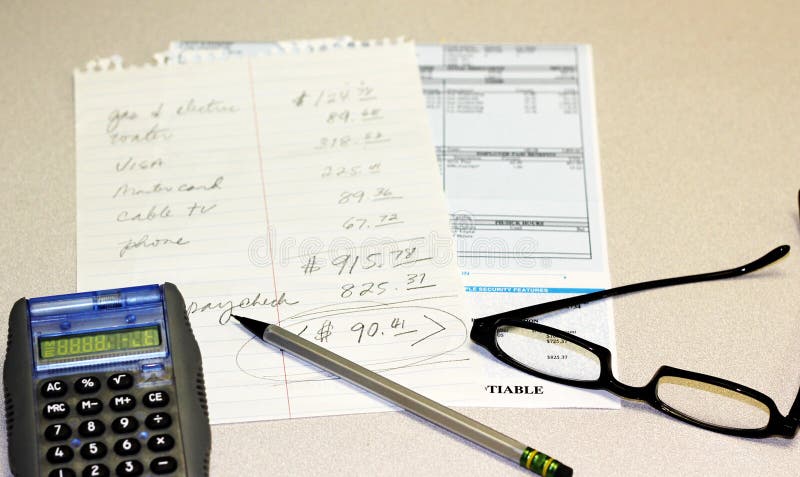 Personal finance metaphor. Photo of a paystub and a list of bills showing a deficit with a calculator, pencil and glasses on the side. Personal finance metaphor. Photo of a paystub and a list of bills showing a deficit with a calculator, pencil and glasses on the side.