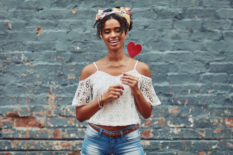 Find yourself, be yourself, love yourself. an attractive young woman posing against a brick wall outside. stock photography