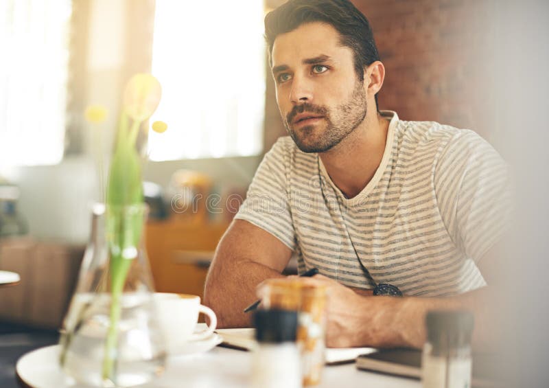 Finding Inspiration at a Buzzing Cafe. a Young Man Looking Thoughtful