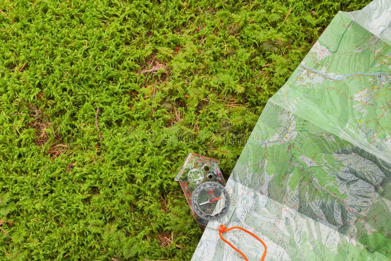 Finding the right position in the forest with a map and kompass stock photo Finding the right position in the forest with a map and kompass stock photo