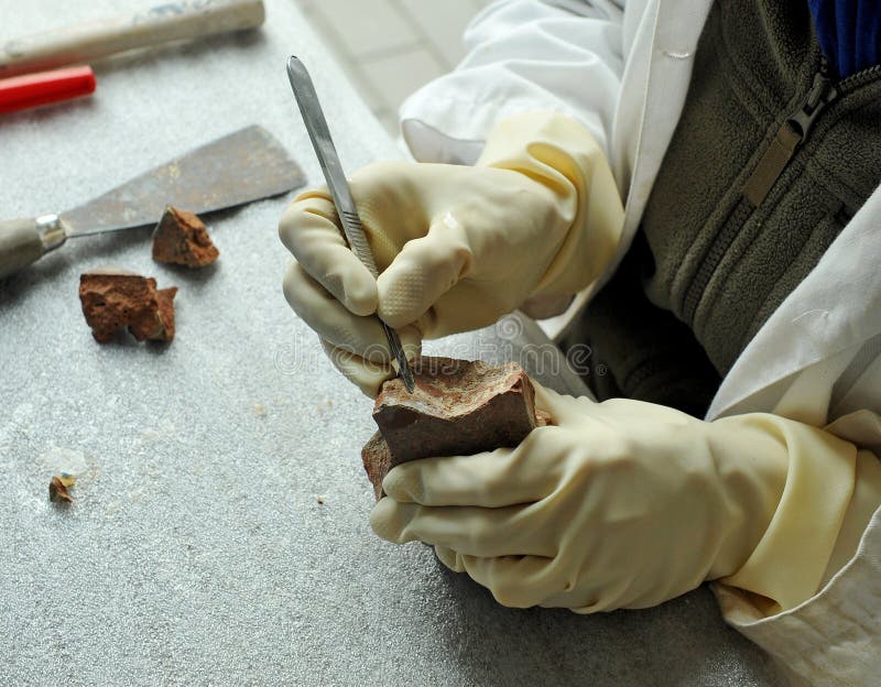 A fine arts restorer cleaning the antique ceramic with scalpel royalty free stock image A fine arts restorer cleaning the antique ceramic with scalpel royalty free stock image