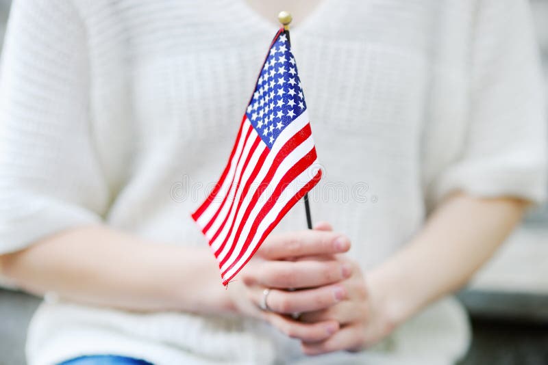 Fine della bandiera americana della tenuta della giovane donna su immagine stock Fine della bandiera americana della tenuta della giovane donna su immagine stock