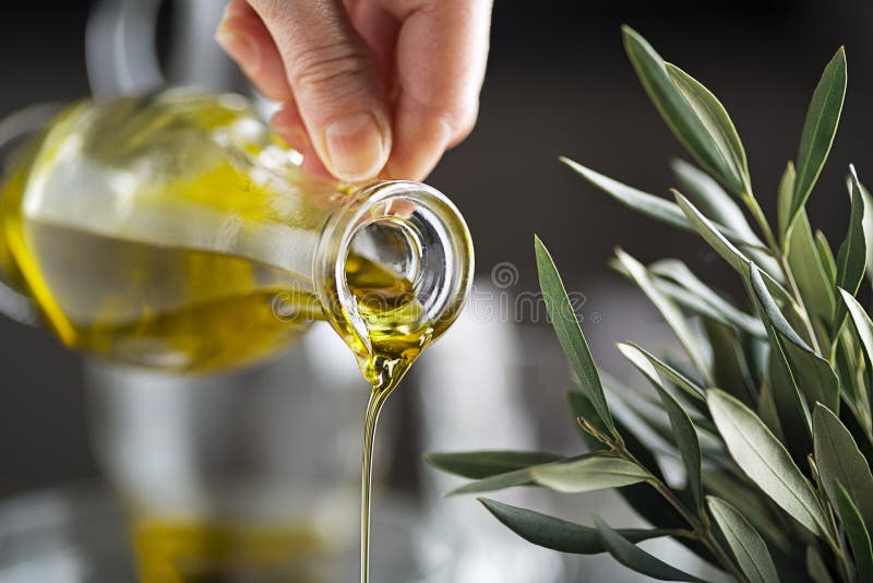 Fine di versamento della bottiglia di olio d'oliva su fotografia stock libera da diritti Fine di versamento della bottiglia di olio d'oliva su fotografia stock libera da diritti