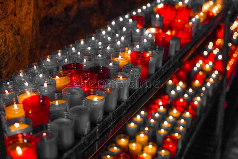 Fine rossa desaturata su delle candele variopinte in una scena spirituale scura Commemorazione, funerale, memoriale Simbolismo re