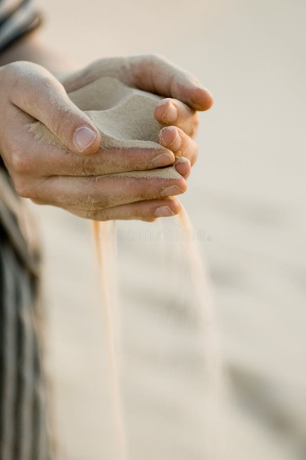 Fine sand leaking through hands - Sahara desert, vertical