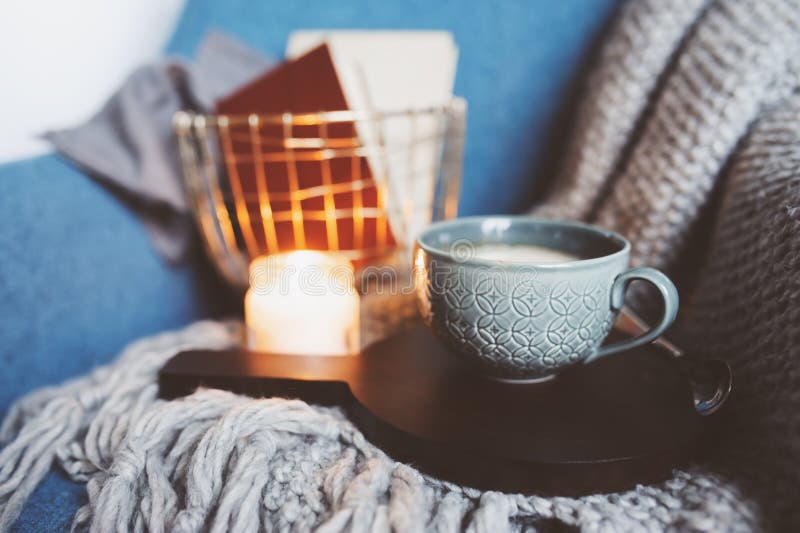 Cozy winter weekend at home. Morning with coffee or cocoa, books, warm knitted blanket and chair. Hygge concept. Cozy winter weekend at home. Morning with coffee or cocoa, books, warm knitted blanket and chair. Hygge concept.