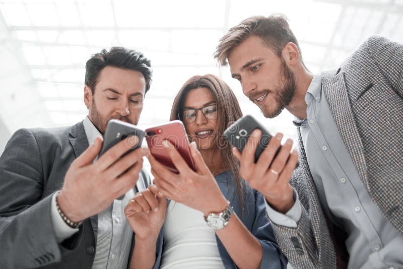 Fine in su colleghi di affari che leggono SMS sui loro smartphones fotografia stock Fine in su colleghi di affari che leggono SMS sui loro smartphones fotografia stock