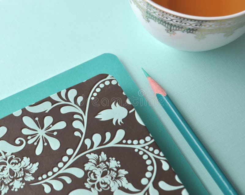 Fine white porcelain china cup with tea, teal pencil, white note card and aqua mint blue background royalty free stock images Fine white porcelain china cup with tea, teal pencil, white note card and aqua mint blue background royalty free stock images