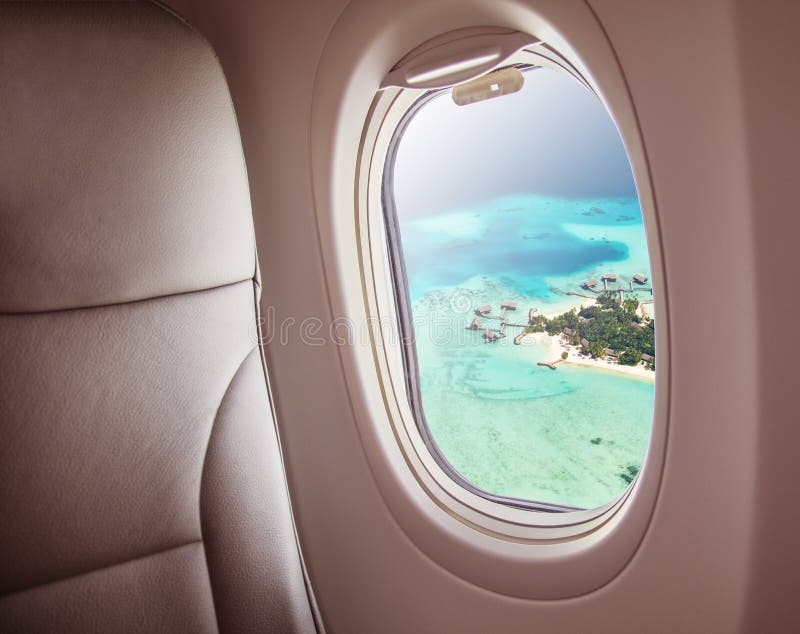 Finestra dell'aeroplano con la bella vista dell'isola delle Maldive immagine stock Finestra dell'aeroplano con la bella vista dell'isola delle Maldive immagine stock