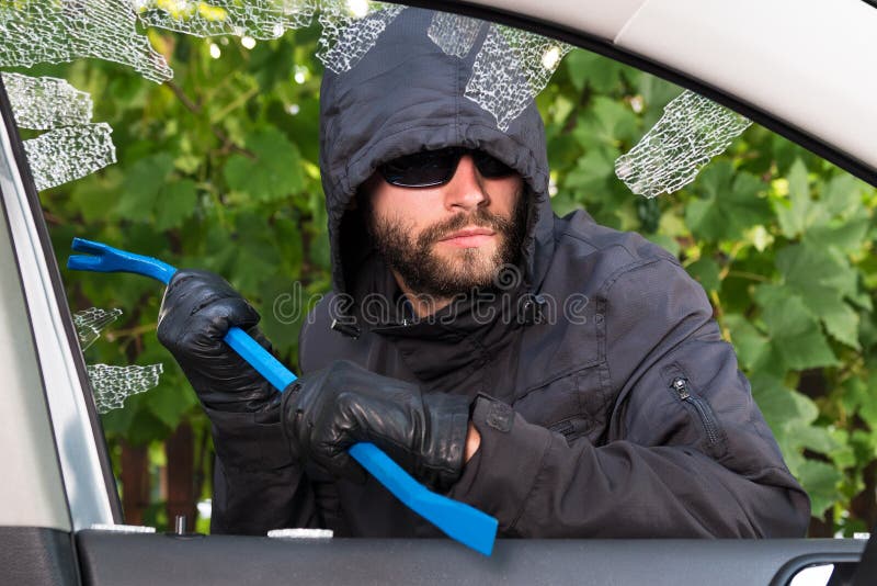 Thief successfully breaking a vehicle's window. Thief successfully breaking a vehicle's window.