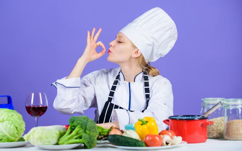 Finger licking good. Pretty woman chef gesturing ok. Kitchen maid preparing vitamin food. Professional cook with vitamin