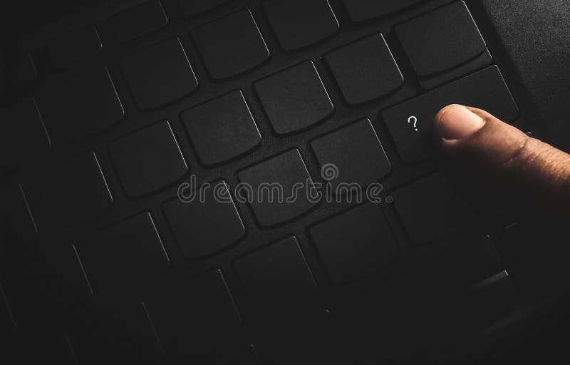 Finger press on question mark keyboard button in the dark