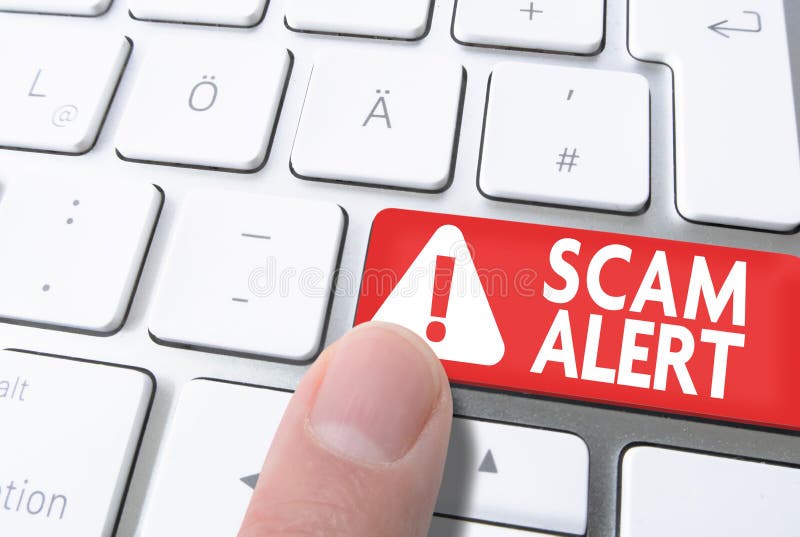 Finger pressing red key labeled SCAM ALERT on computer keyboard stock image