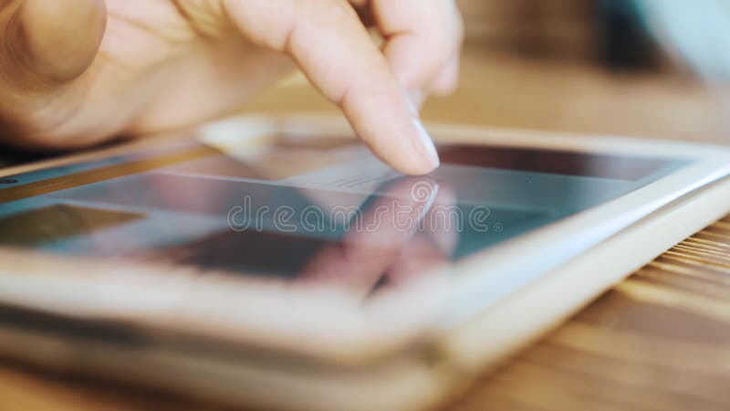 Finger touching screen of modern digital tablet computer and scrolling content.