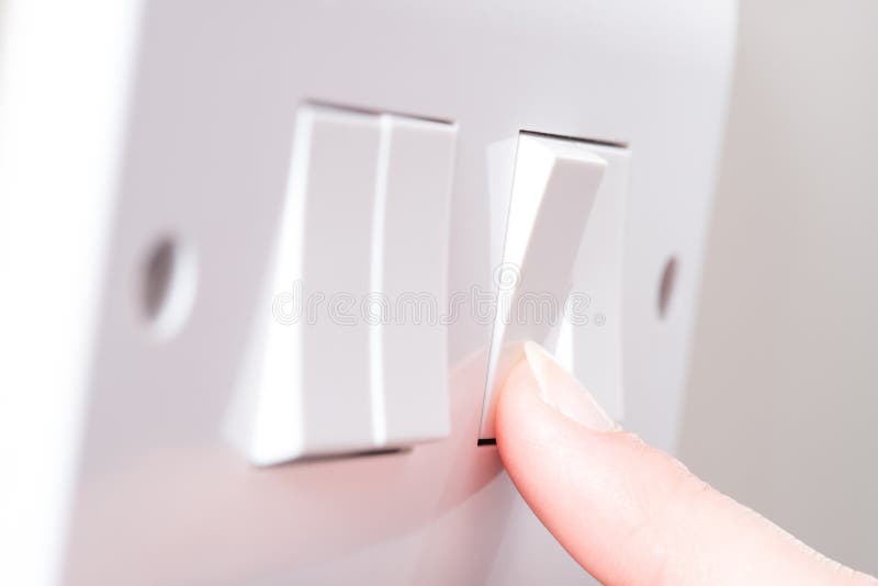 Finger Turning on Light On a 4 Gang Switch Plate royalty free stock photography