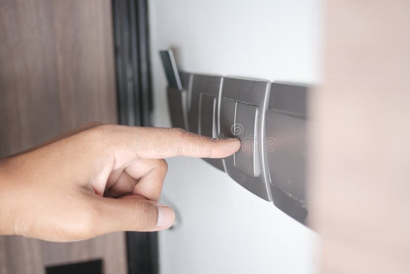 A finger turning on lighting switch. stock photography