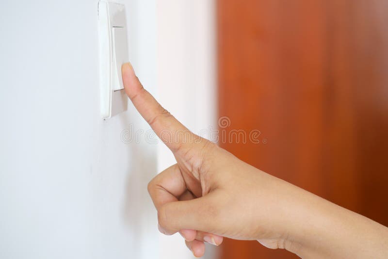 A finger turning on lighting switch. stock photography