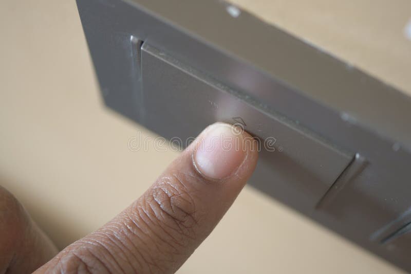 A finger turning on lighting switch. stock images