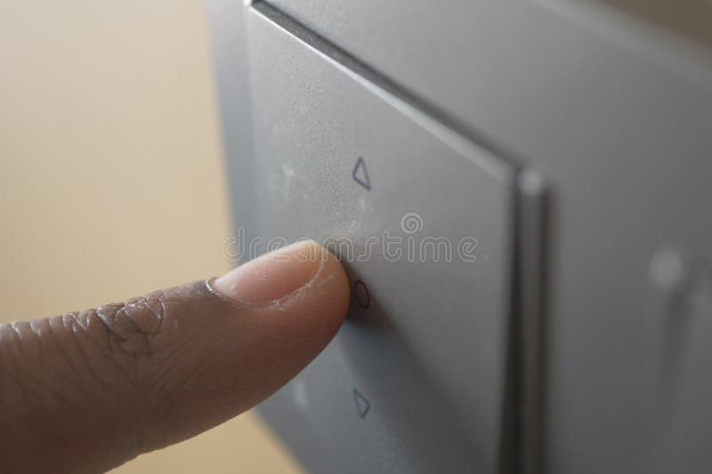 A finger turning on lighting switch. stock photos