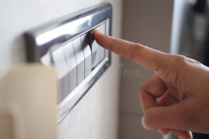 A finger turning on lighting switch. royalty free stock photography