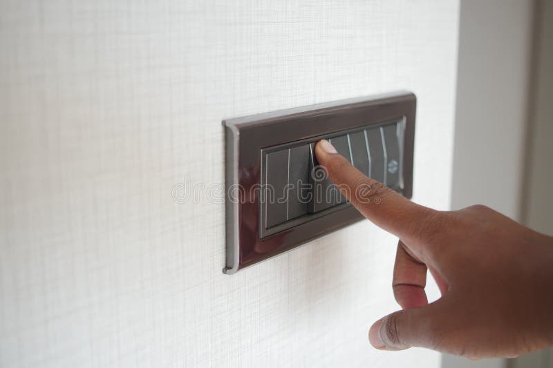 A finger turning on lighting switch. royalty free stock photos