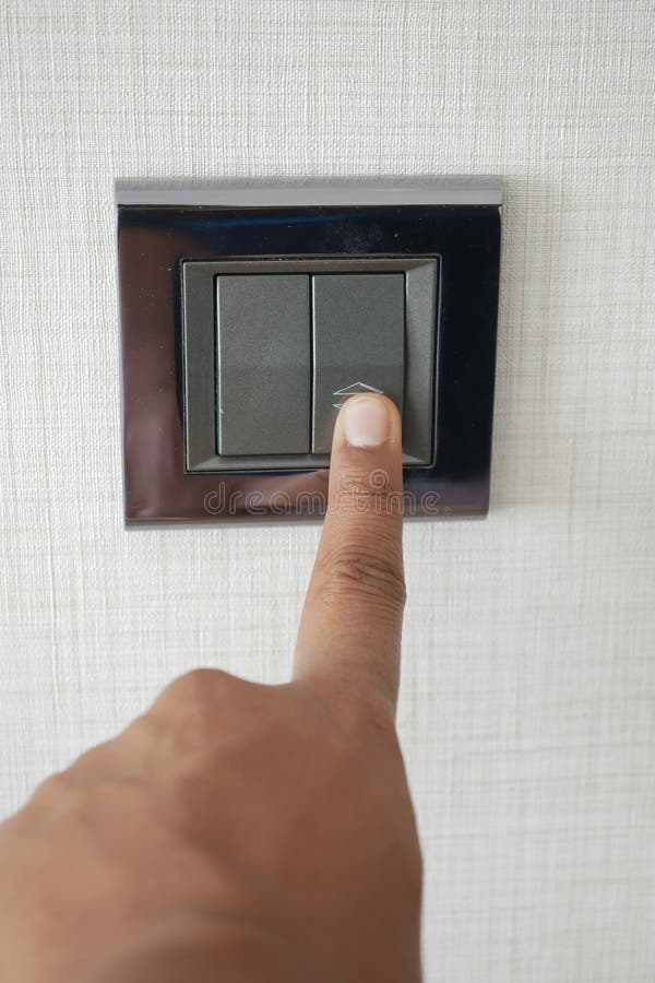 A finger turning on lighting switch. royalty free stock photos