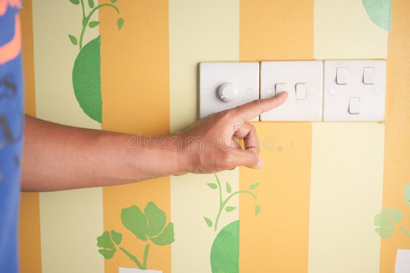 A finger turning on lighting switch. royalty free stock photo