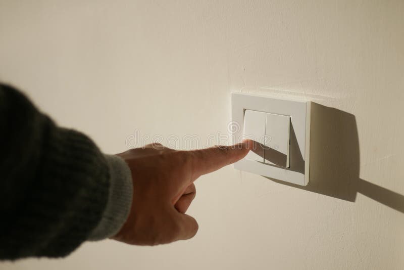 A finger turning on lighting switch. stock photography