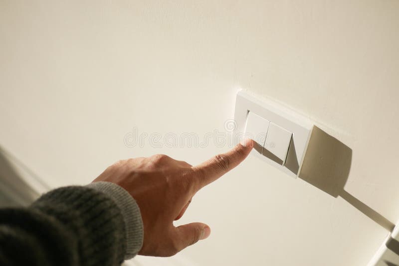 A finger turning on lighting switch. stock photo