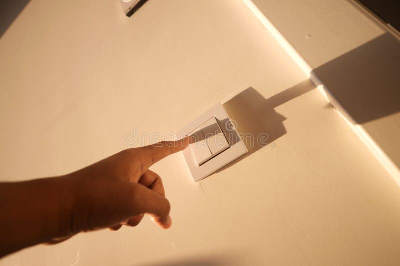 A finger turning on lighting switch. stock images