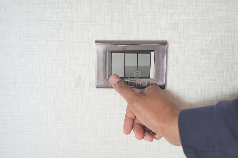 A finger turning on lighting switch with copy space stock photos