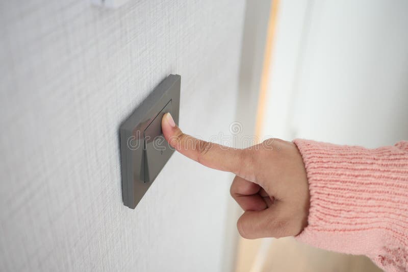 A finger turning on lighting switch. royalty free stock photo