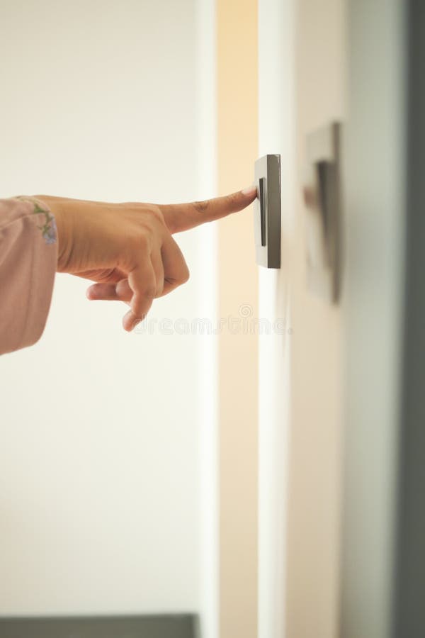 A finger turning on lighting switch. royalty free stock photography
