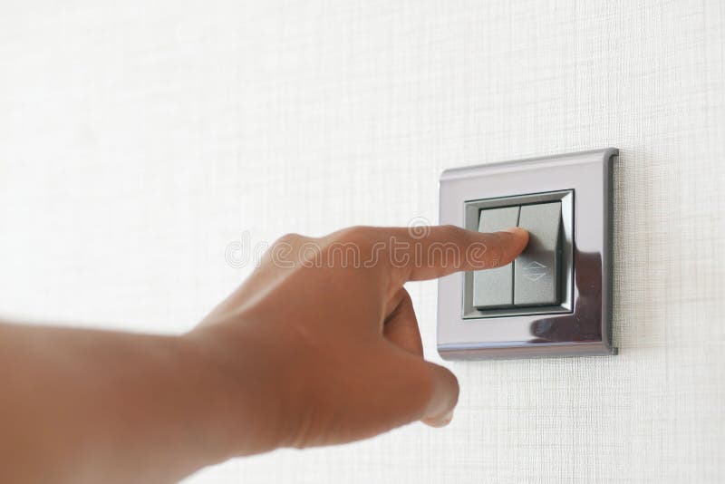 A finger turning on lighting switch. royalty free stock photography