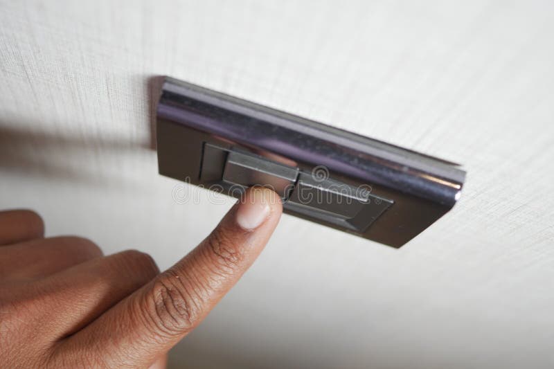 A finger turning on lighting switch. royalty free stock photo