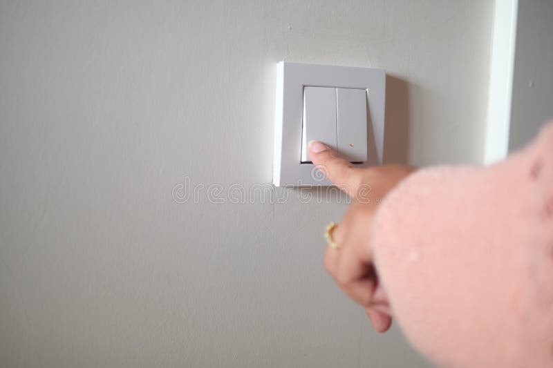A finger turning on lighting switch. royalty free stock photography
