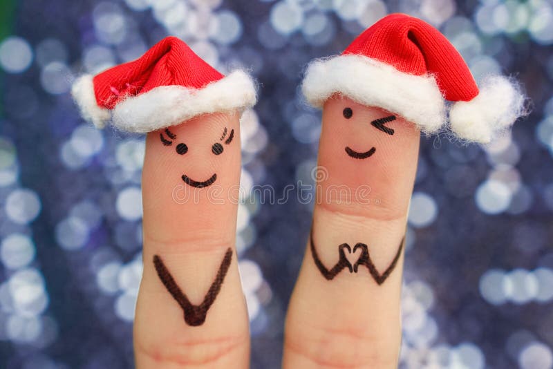 Fingerkonst av par firar jul Begrepp av mannen och kvinnan som skrattar i hattar för nytt år fotografering för bildbyråer Fingerkonst av par firar jul Begrepp av mannen och kvinnan som skrattar i hattar för nytt år fotografering för bildbyråer