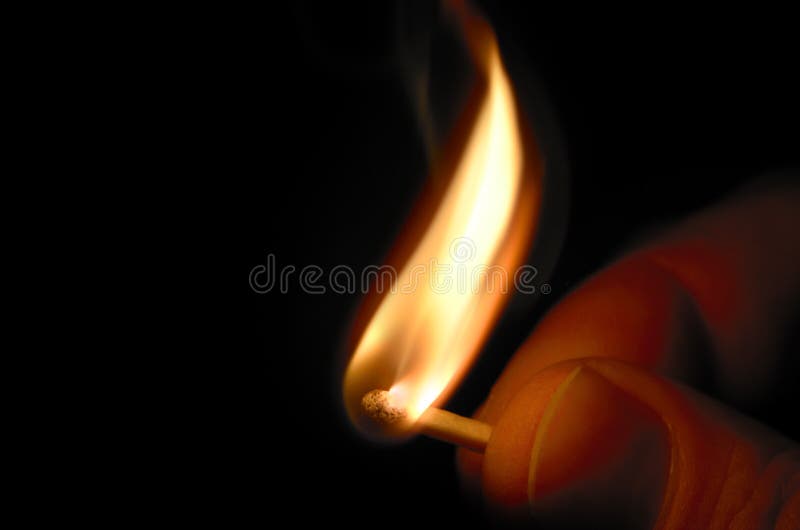 Fingers holding burning match, macro shot