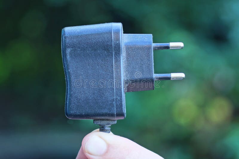 Fingers holding one black electrical socket on a flashlight royalty free stock photo