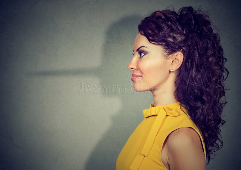 Young beautiful woman concealing lie looking nervous while posing on gray. Young beautiful woman concealing lie looking nervous while posing on gray.