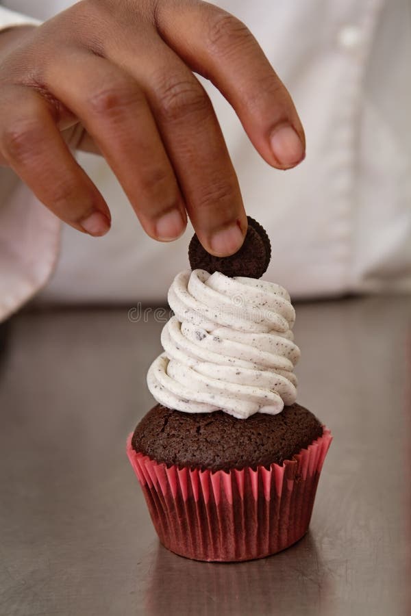 Chef finishing decorating cookies and cream cupcake. Chef finishing decorating cookies and cream cupcake