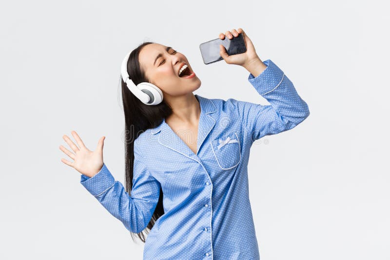 Linda garota asiática usando fone de ouvido aprendendo música de
